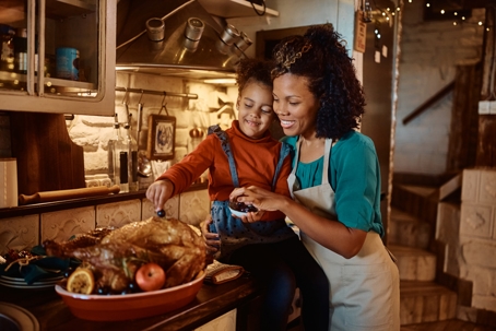 mother and daughter preparing Thanksgiving turkey