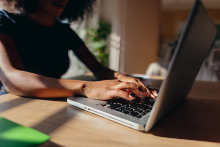 Close-up view of a divorcee typing on a laptop keyboard