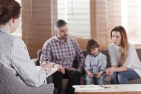 distressed child with parents talking to therapist